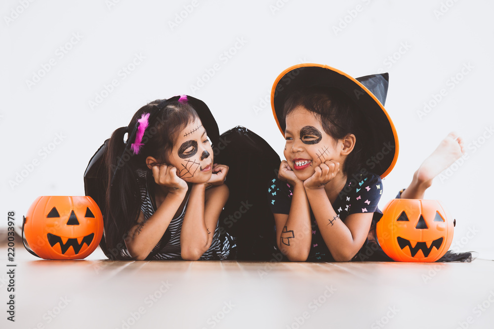 Fototapeta premium Happy asian little child girl in costumes and makeup having fun on Halloween celebration