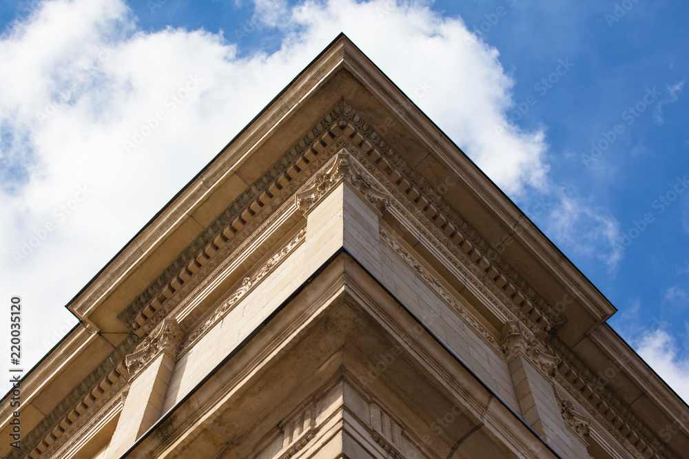 part of the classical façade of a beige historical building with a relief