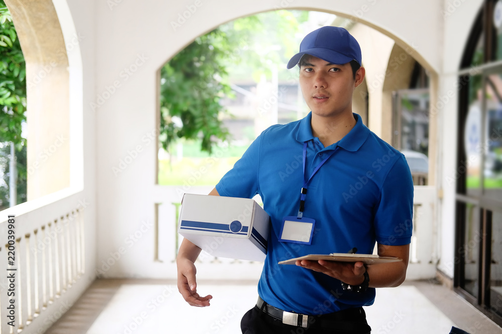 Delivery man in red cap standing with parcel post box. Delivery man in red cap standing with parcel post box.