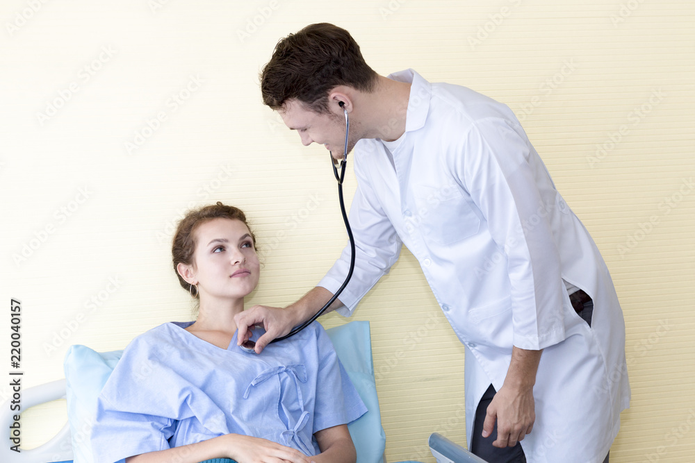 Obraz premium Medical professionals caucasian man examining patient with stethoscope in hospital, doctor using stethoscope to exam young woman check up.Close up.