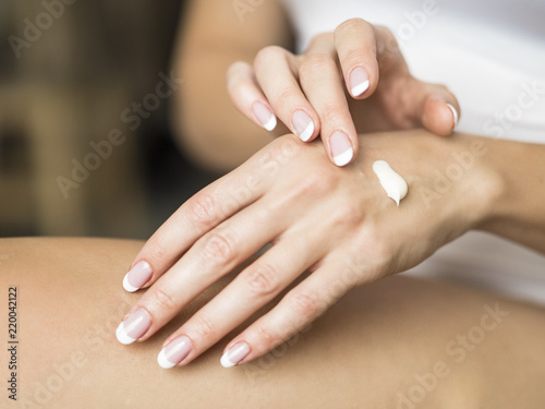Young woman applying hand cream  closeup view