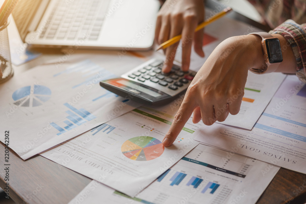 Businesswoman or accountant working on calculator to calculate business data, and accountancy document. Business financial and accounting concept. Businesswoman or accountant working on calculator to calculate business data, and accountancy document. Business financial and accounting concept.
