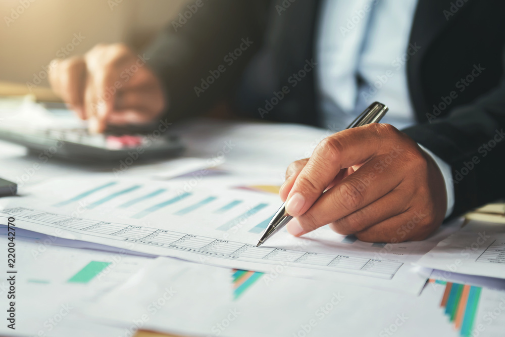 businessman using pen and calculator working in office. finance and accounting businessman using pen and calculator working in office. finance and accounting