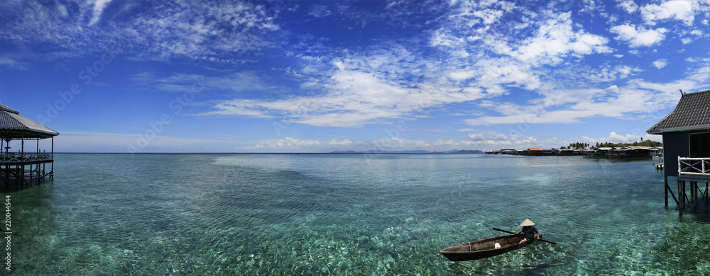 Fototapeta premium Fisherman in his boat on turquoise sea