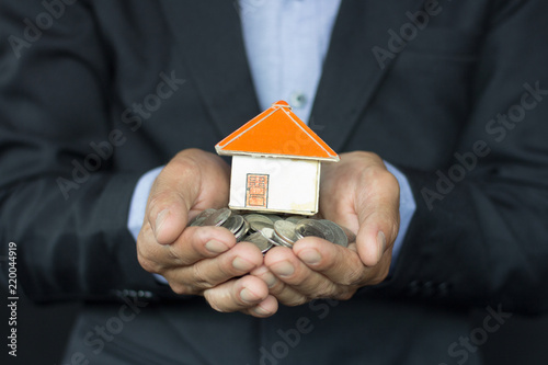 House models and coin in human hands, Mortgage concept by money house from the coins.