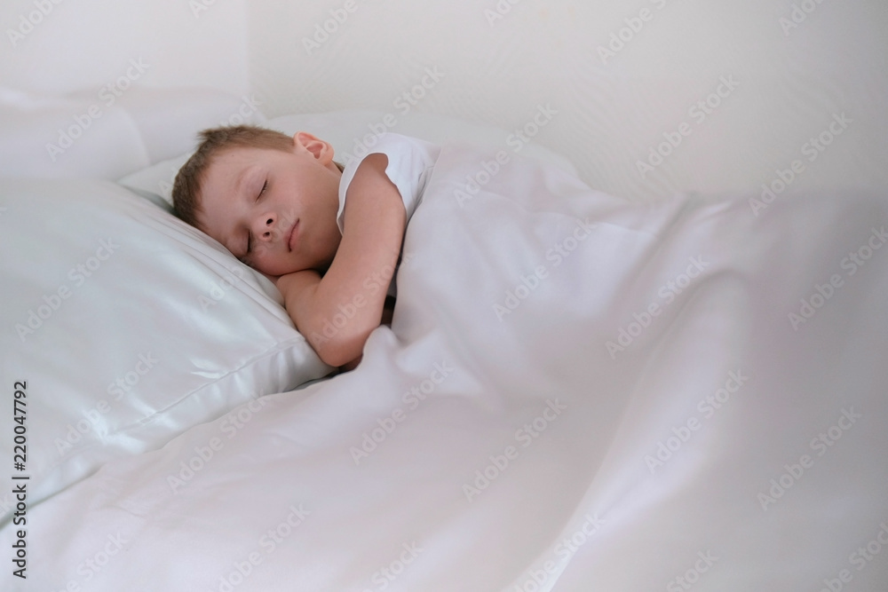 Seven year old boy wrapped himself in a blanket and sleeps. Seven year old boy wrapped himself in a blanket and sleeps.