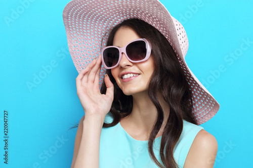 Fashion portrait of young woman wearing hat and sunglasses.