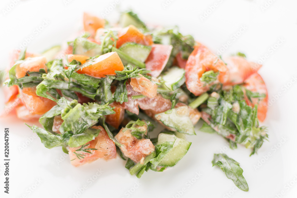 Salad of fresh vegetables - cucumber, tomato, greens with sour cream. Salad of fresh vegetables - cucumber, tomato, greens with sour cream.