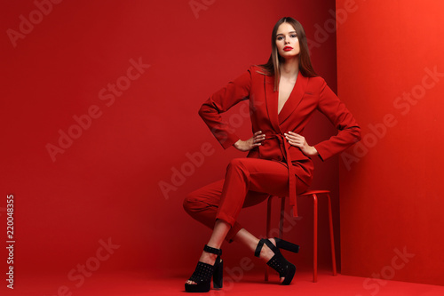 Fashion young woman in red suit.