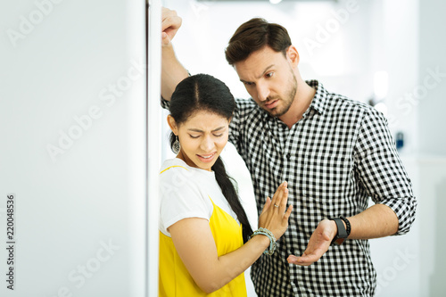 Leave me alone. Serious man leaning to a scared girl and looking pushy while the girl trying to escape from him
