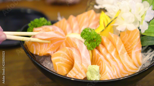 Chopstick Bowl of raw slice salmon sashimi in japanese restaurant