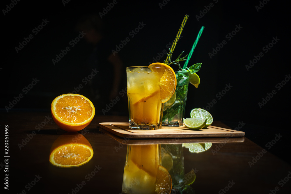 Fototapeta premium Fresh cocktail on a black background. Alcoholic cocktail on a black background. Fruit with a cocktail. Non-alcoholic cocktail. Mix of cocktails on a black background. 
