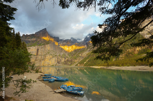 On the bank of a lake of Oeschinensee during a sunset  Switzerland