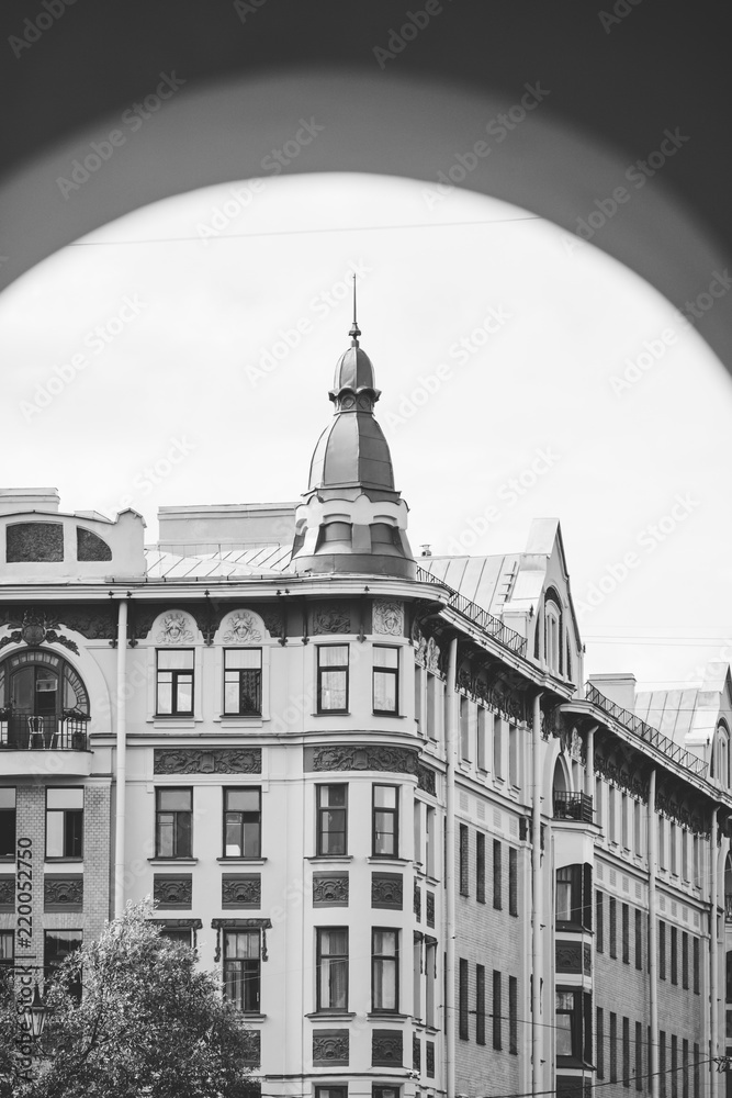 View through the arch to the house of European architecture on Vasilievsky Island in St. Petersburg city. Black and white photography.