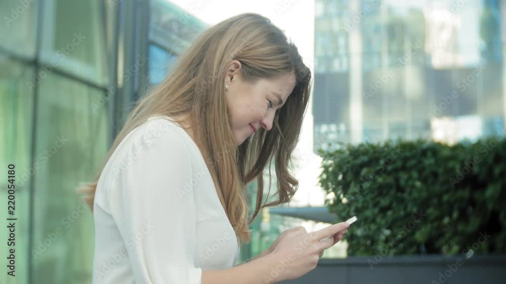 Young businesswoman talking is using smartphone in city park business center Young businesswoman talking is using smartphone in city park business center