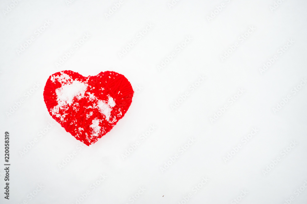 Beautiful romantic vintage red thread heart on a white snow winter background. Heart handmade symbol against snow background. Love Romantic and Valentines Day concept.