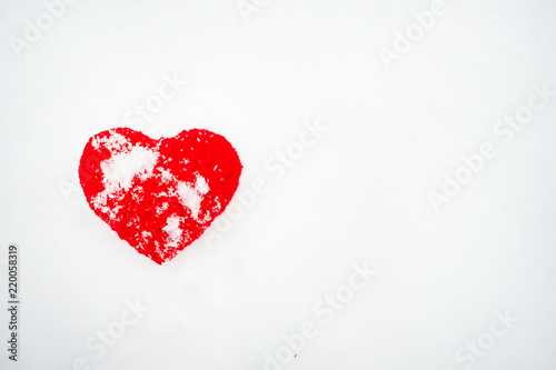 Beautiful romantic vintage red thread heart on a white snow winter background. Heart handmade symbol against snow background. Love Romantic and Valentines Day concept.