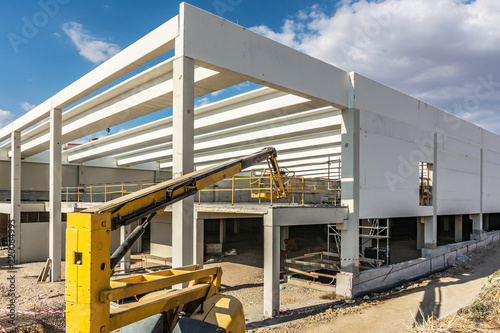 Construction site of an industrial warehouse with a mobile elevator photo