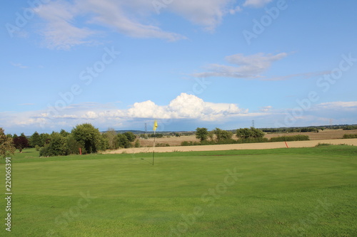Golf green overlooking farmers field © Jack