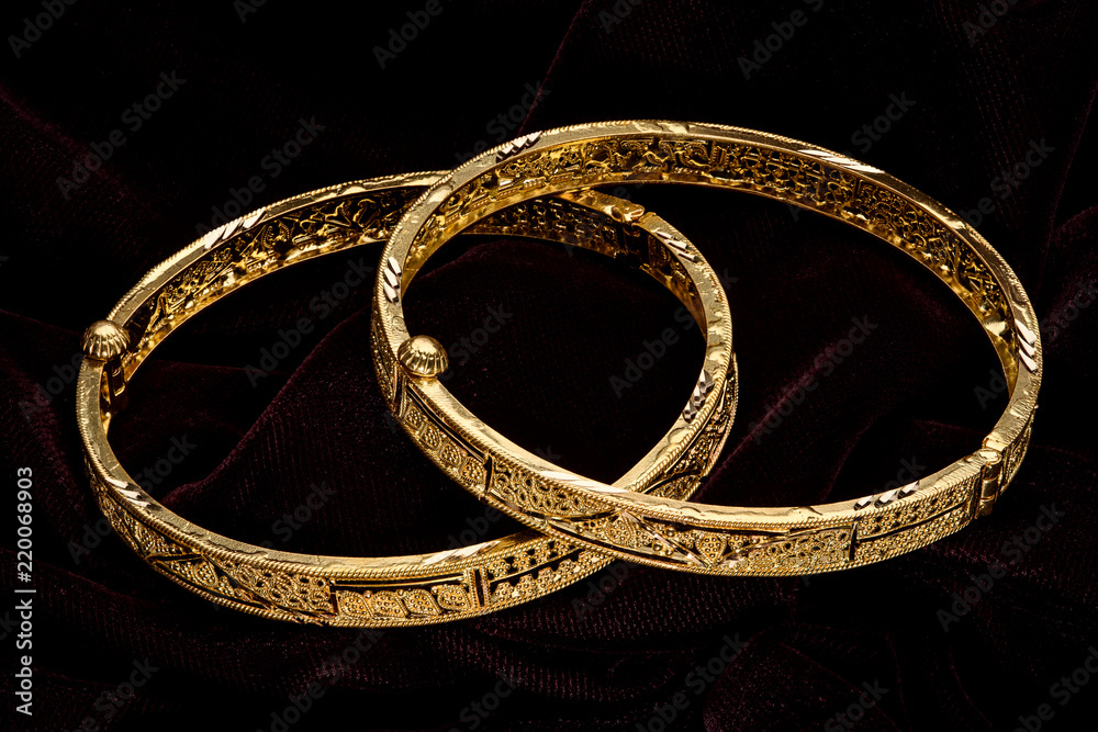 Golden bracelet on a dark pattern Golden bracelet on a dark pattern