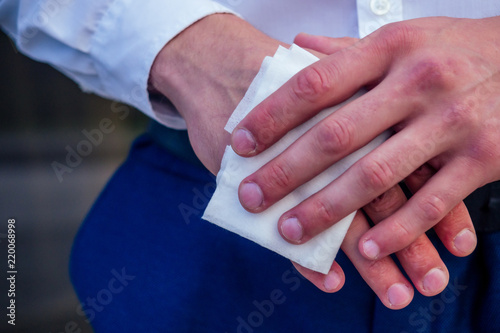 close-up hands of man using a antibacterial wet napkin wipe