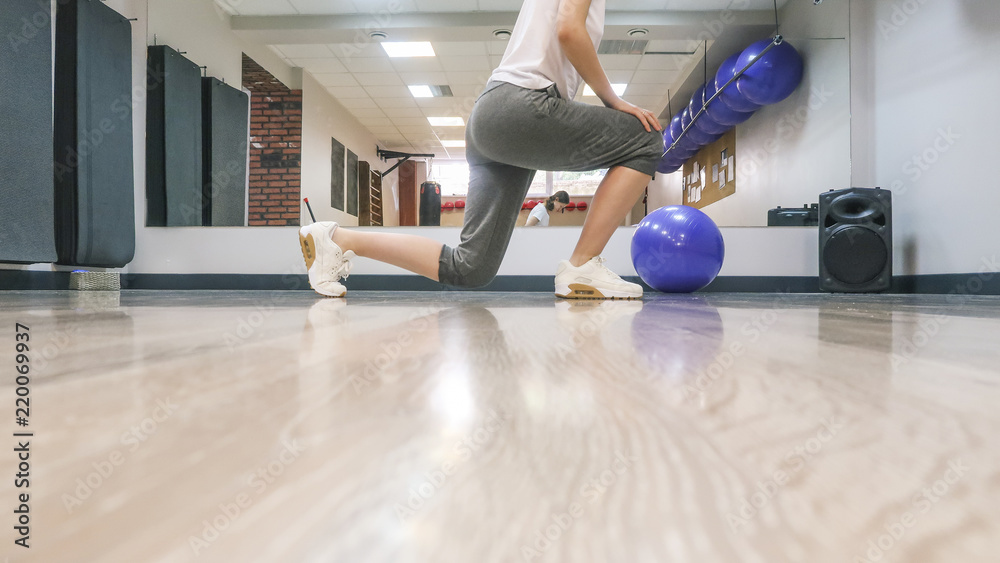 Determined young woman doing stretching fitness exercise at sport gym. Woman's health Determined young woman doing stretching fitness exercise at sport gym. Woman's health
