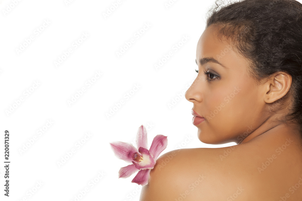profile of young beautiful dark-skinned woman with orchid on a white background profile of young beautiful dark-skinned woman with orchid on a white background
