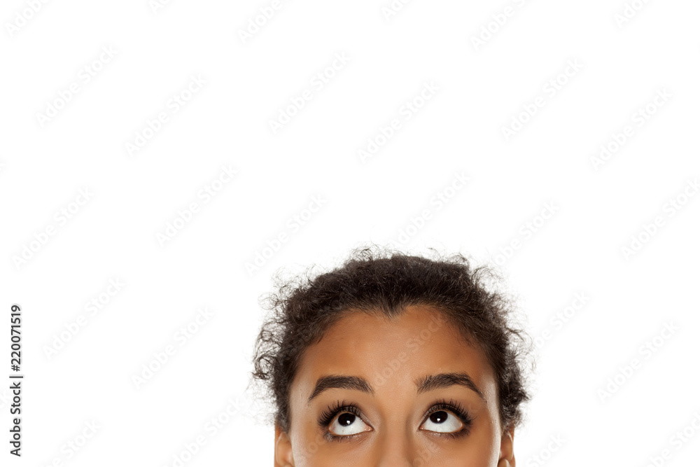half portrait of a young dark skinned girl looking up on white background - obrazy, fototapety, plakaty 