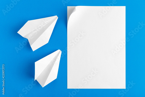 Flat lay of a paper plane on pastel blue color background