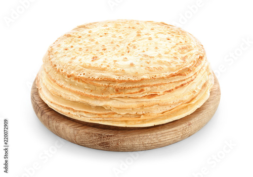 Wooden board with stack of tasty thin pancakes on white background