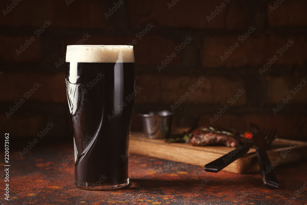 Glass of cold dark beer on color table - obrazy, fototapety, plakaty 