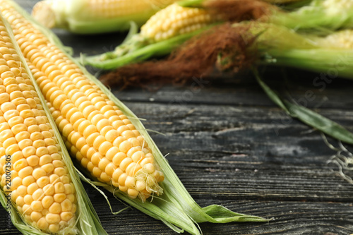 Fresh corn cobs on wooden background  closeup