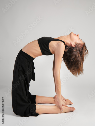 Sporty woman practicing yoga on grey background