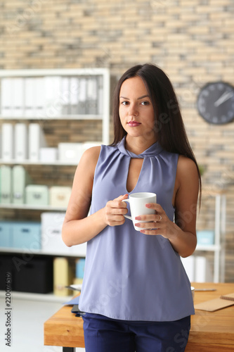 Young businesswoman drinkin...