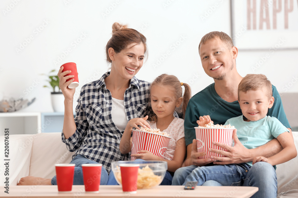 Family eating popcorn while watching TV at home Family eating popcorn while watching TV at home