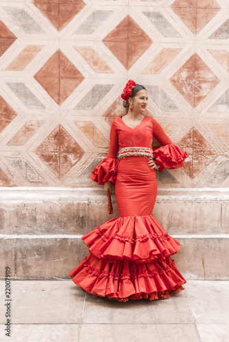 Woman dressed in red dancing flamenco with red fan