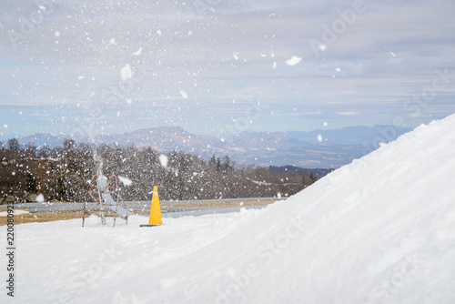 Wide detail of pipe connected to snowmaking machine spraying snow into the air and onto the slopes of the Gokase Highlands ski area. Miyazaki, Japan. Travel and winter sports. photo