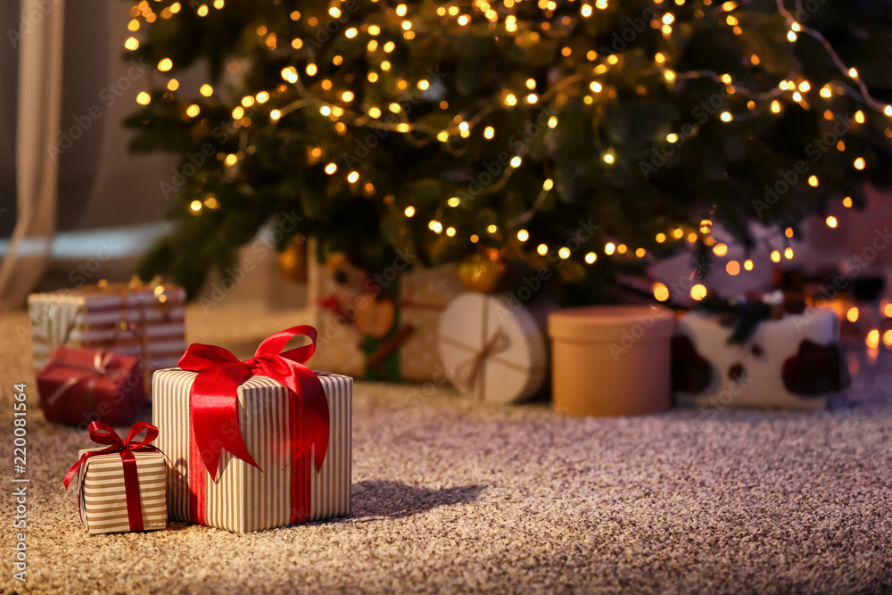 Beautiful Christmas gift boxes on floor near fir tree in room - obrazy, fototapety, plakaty 