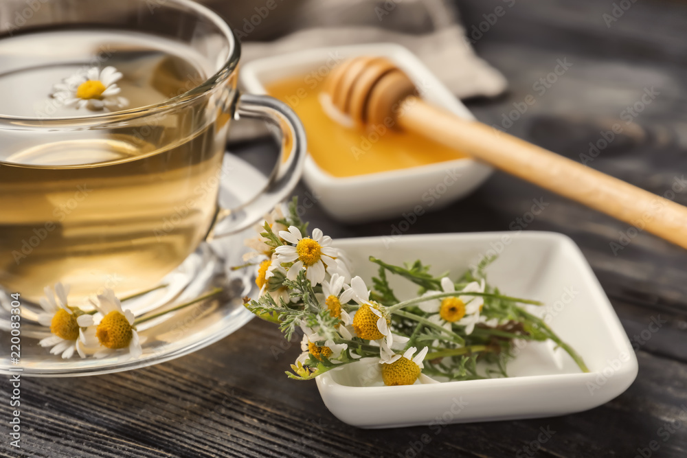 Cup of delicious camomile tea and honey on wooden table, closeup Cup of delicious camomile tea and honey on wooden table, closeup