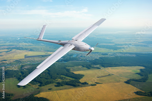 Unmanned military drone on patrol air territory at low altitude.
