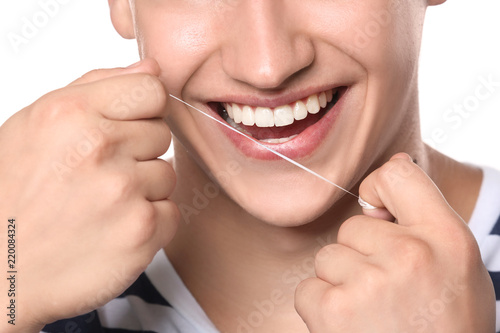 Young man flossing teeth on white background  closeup