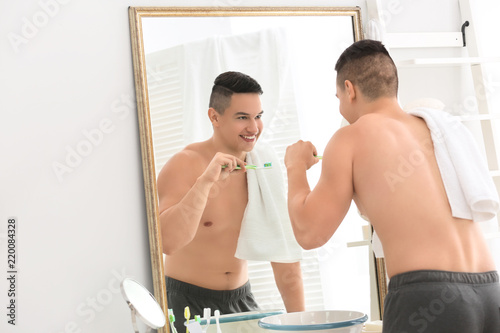 Young man brushing teeth in...