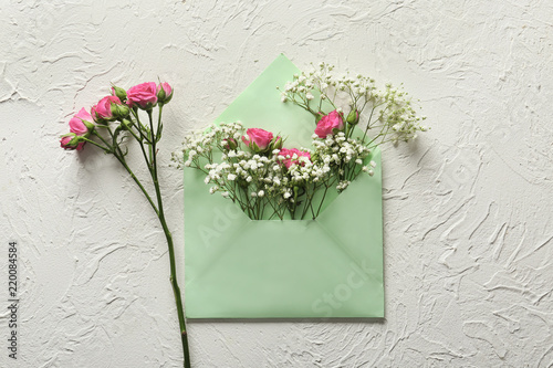 Fototapeta Naklejka Na Ścianę i Meble -  Beautiful flowers with envelope on light textured background