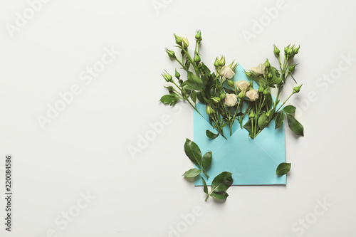 Open mail envelope with rose flowers on white background