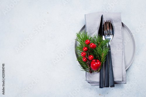 Foto Christmas table place setting with tree fir branches, napkin, fork, knife, spoon and festive decoration