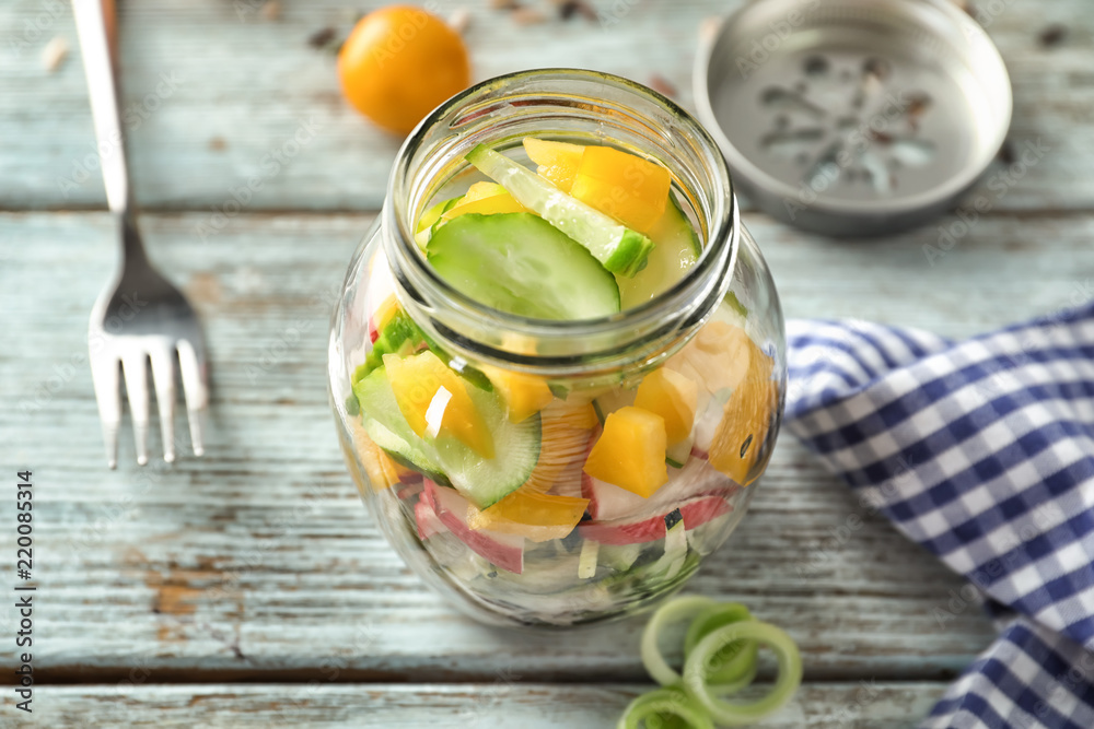 Delicious vegetable salad in mason jar on wooden table Delicious vegetable salad in mason jar on wooden table