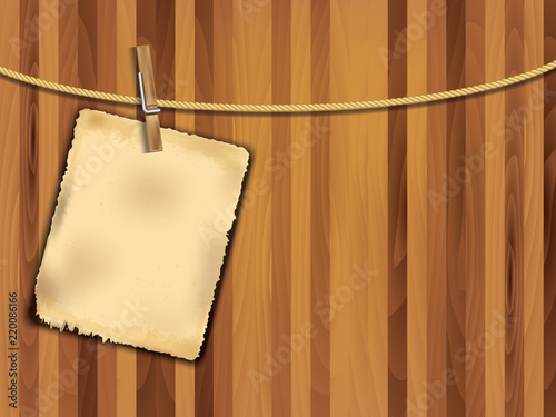 Old classic paper on wooden background with wooden clip and rope
