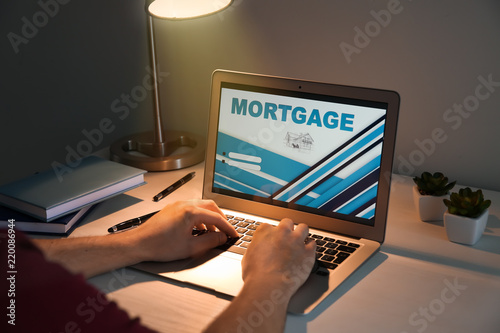 Man using laptop to pay mor...