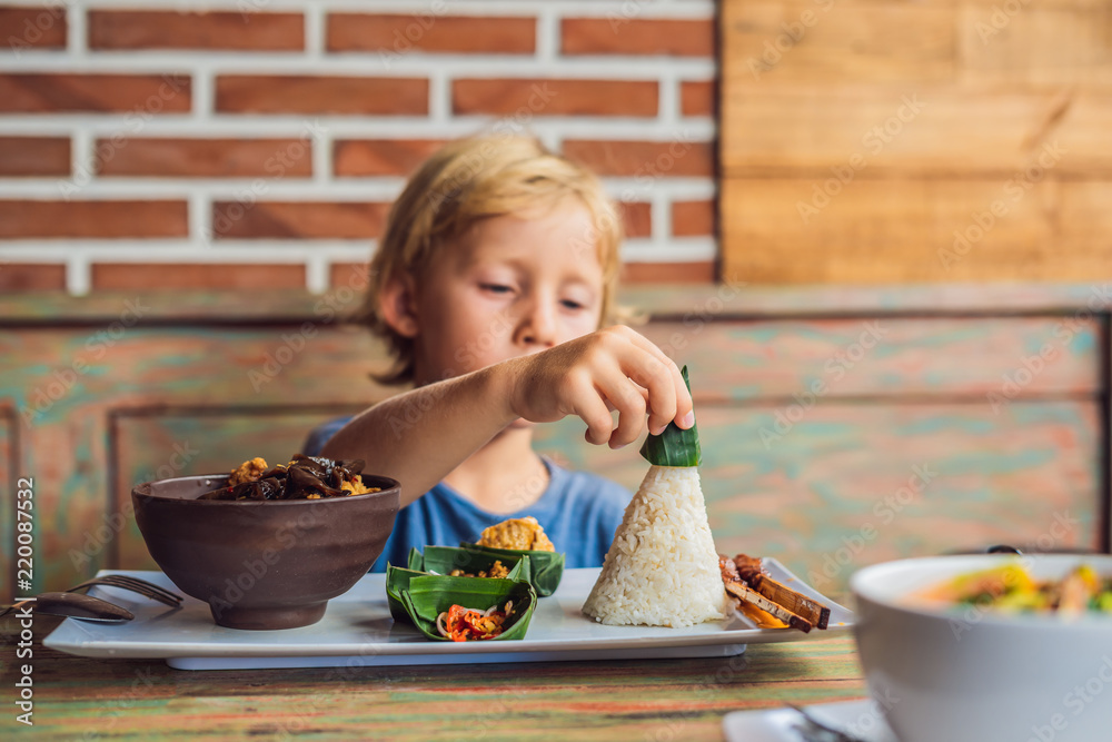 Boy eats in a cafe. Lifestyle. A dish consisting of rice, fried fish
