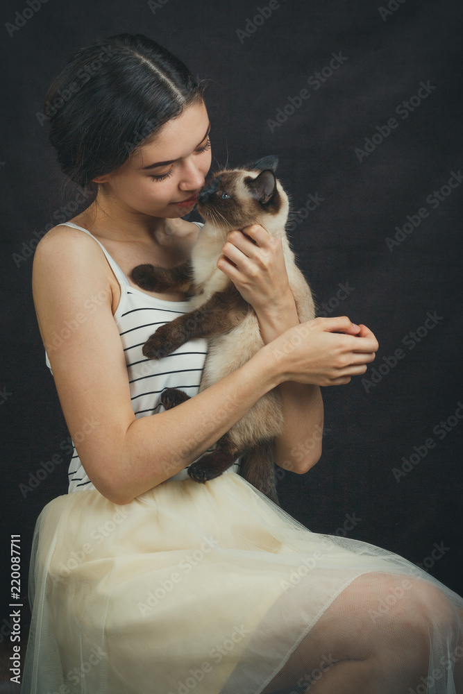 Portrait of a beautiful young girl with a cat